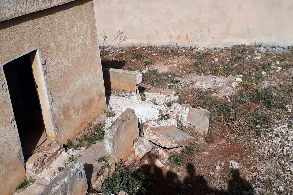 Trümmerteile einer Mauer versperren fast den Eingang eines verlassenen Schulgebäudes in Syrien