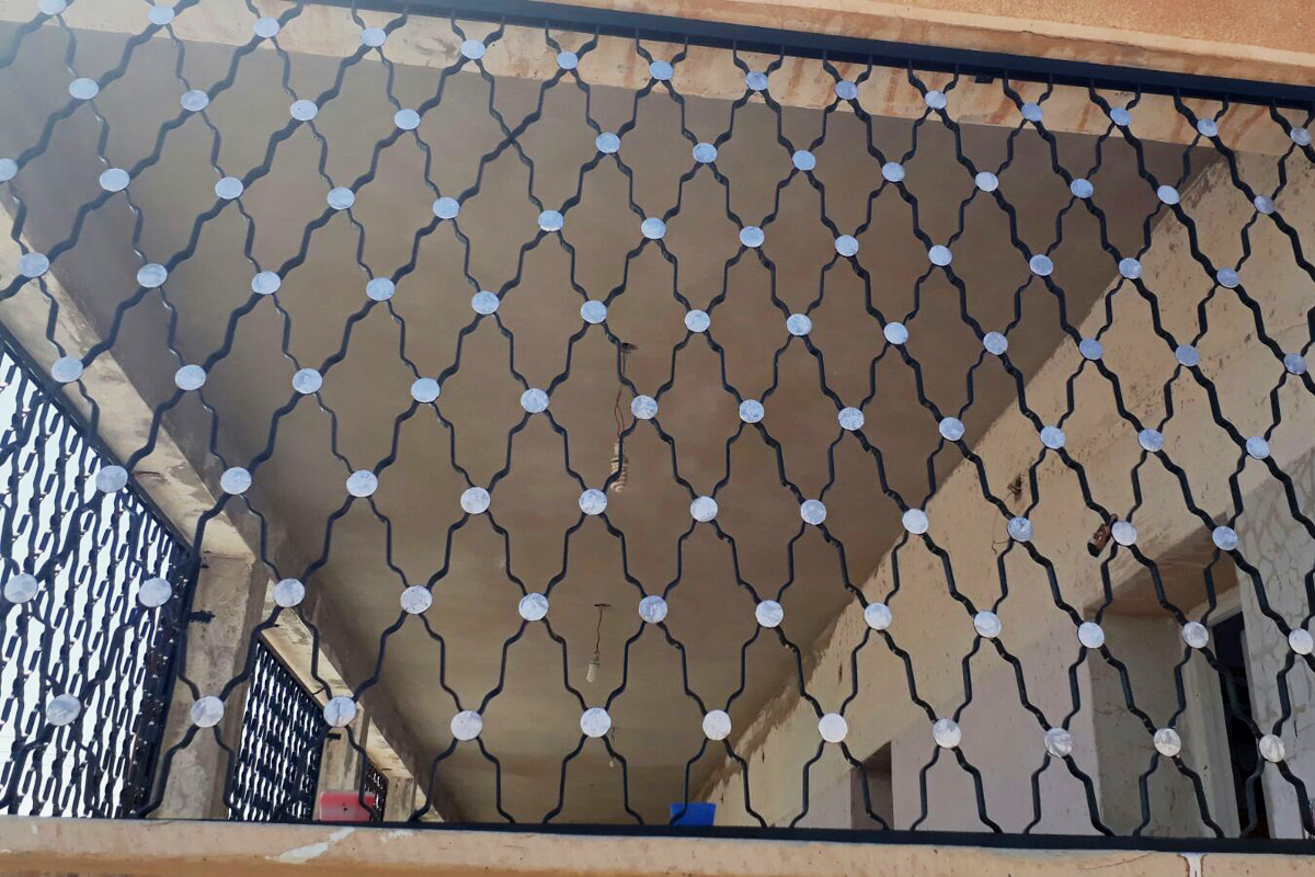 Dekorative, neu geschmiedete Gitter an den Fenstern.